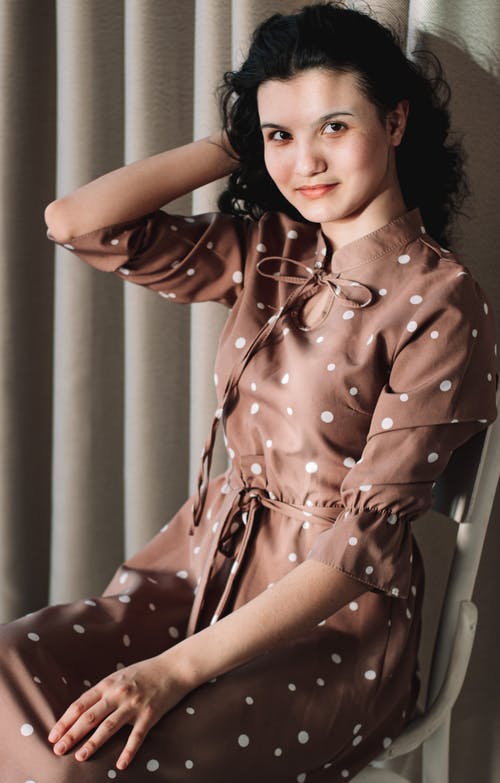 有关圆点连衣裙, 坐, 垂直拍摄的免费素材图片