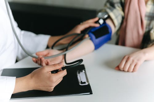一名医护人员使用血压计测量患者的血压 · 免费素材图片