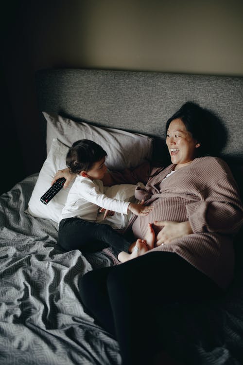 怀孕的母亲和婴儿躺在床上 · 免费素材图片