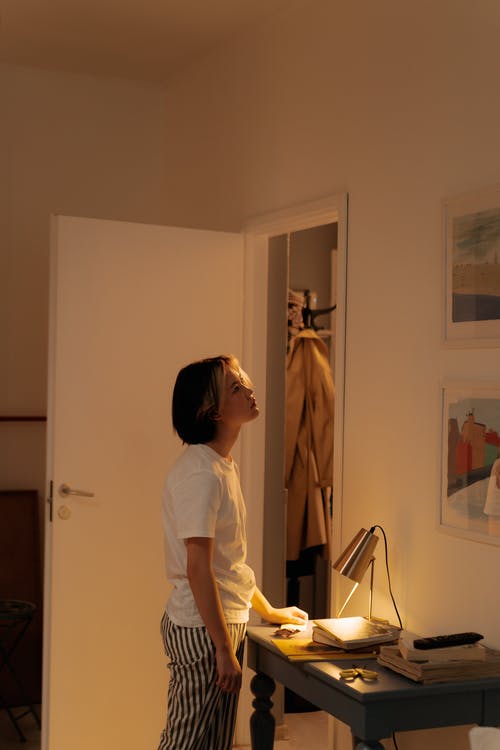 站在白墙附近的白衬衫的女人 · 免费素材图片