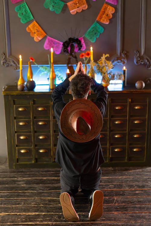 穿黑夹克的男人站在棕色木制抽屉附近 · 免费素材图片