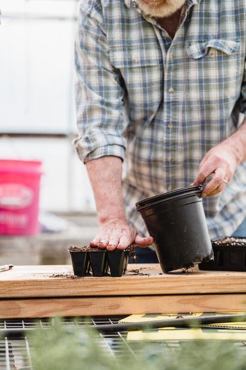 持有黑色塑料桶的人 · 免费素材图片