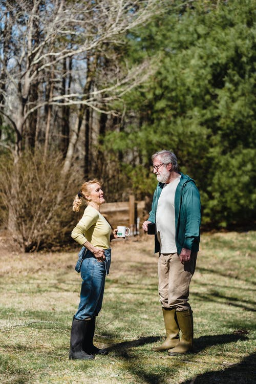 老夫妇一起站在草地上 · 免费素材图片