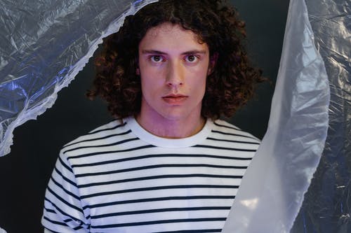 有关人, 捲髮, 条纹衬衫的免费素材图片