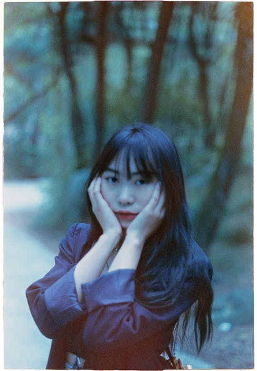 有关亚洲 wonan, 双手放在脸上, 垂直拍摄的免费素材图片