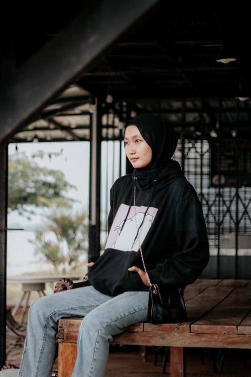 有关双手插在口袋里, 坐, 垂直拍摄的免费素材图片