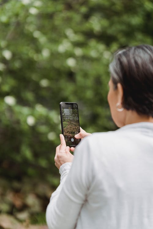 女人用她的智能手机拍照 · 免费素材图片