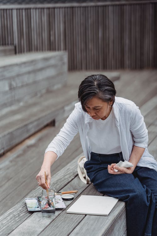 女人在水中浸泡她的画笔 · 免费素材图片