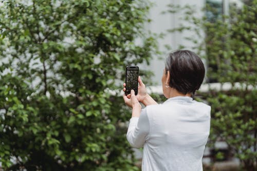 女人用她的智能手机拍照 · 免费素材图片