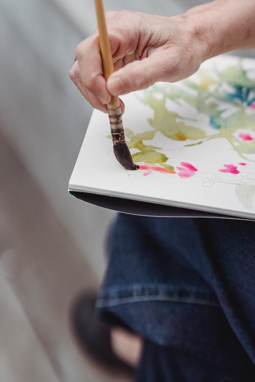 一个人在画一件艺术品的特写照片 · 免费素材图片