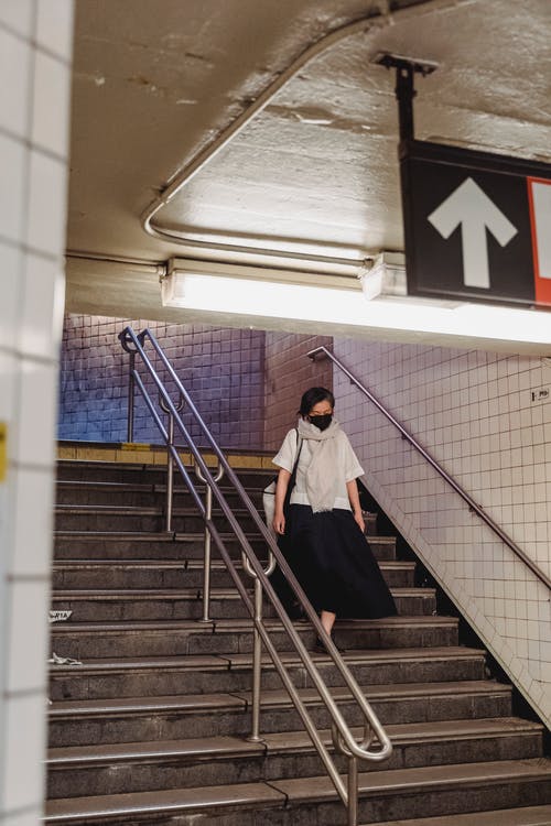 一个女人走在地铁站内 · 免费素材图片