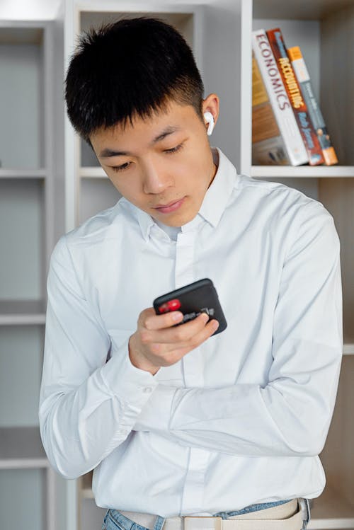 有关垂直拍摄, 用电话, 白色长袖的免费素材图片