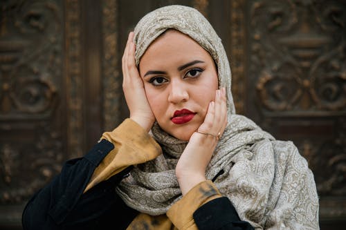 戴头巾的女人抚摸她的脸 · 免费素材图片