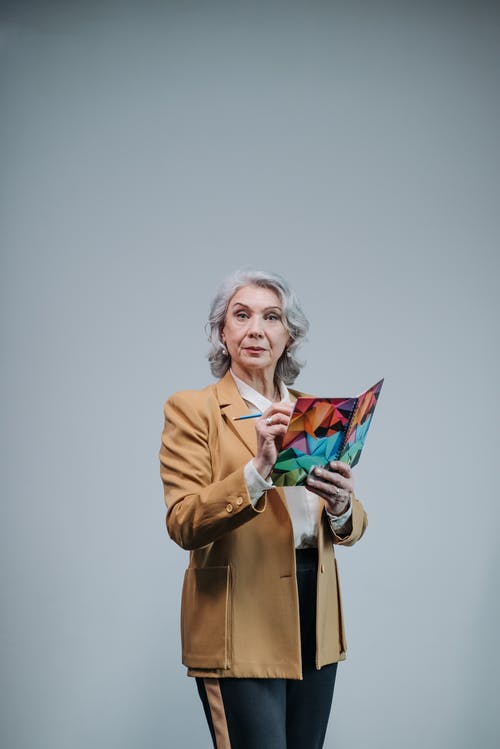 有关垂直拍摄, 握住, 棕色西装外套的免费素材图片