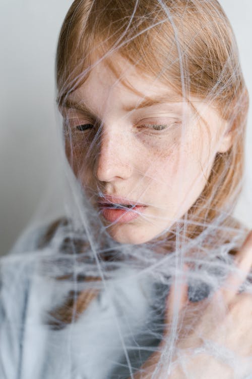 被蜘蛛网困住的无助女人的特写照片 · 免费素材图片