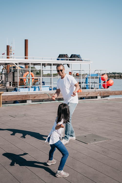 爸爸和女儿在木码头上玩耍 · 免费素材图片