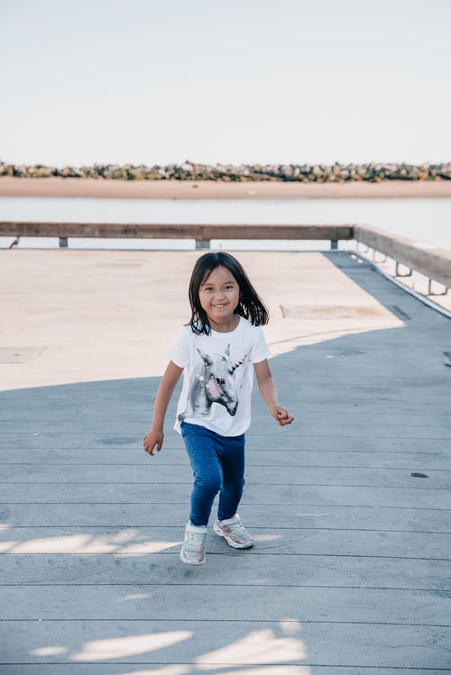 看着相机的白衬衫的可爱女孩 · 免费素材图片