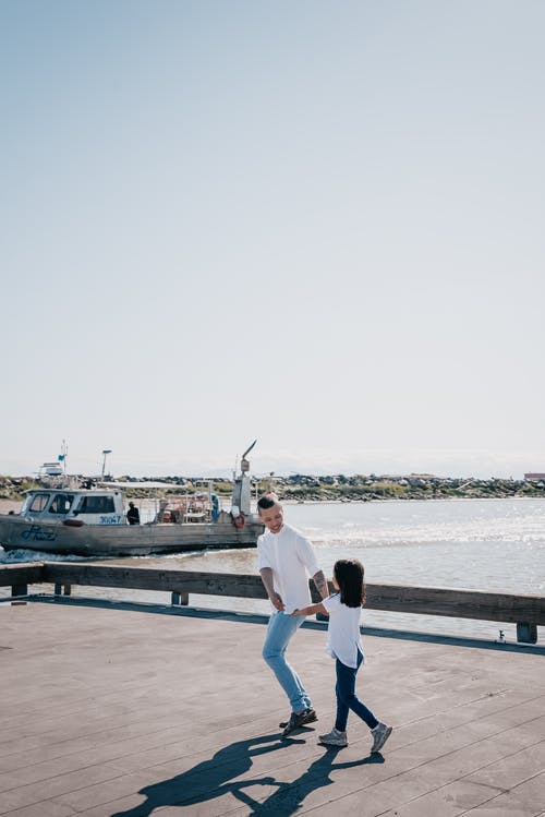 爸爸和女儿在木码头上玩耍 · 免费素材图片