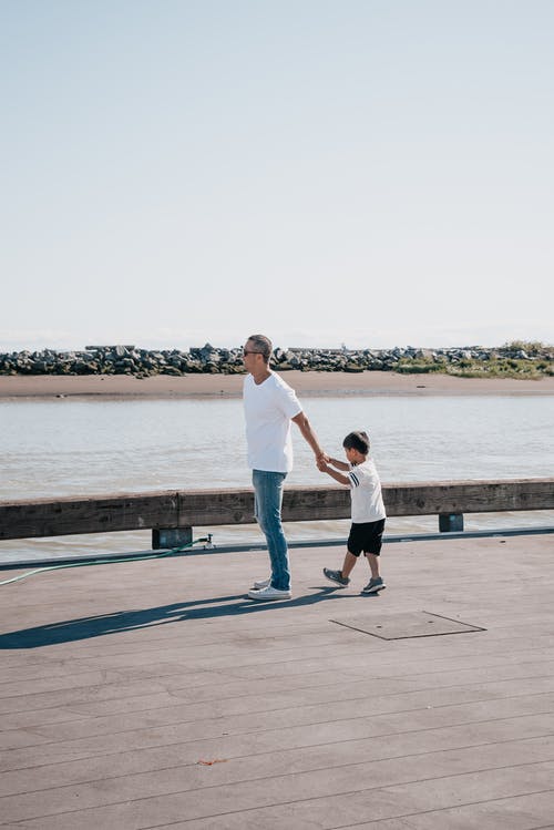 爸爸和儿子一起站在木码头上 · 免费素材图片