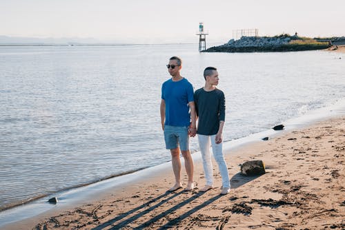 一对情侣在沙滩上手牵手 · 免费素材图片