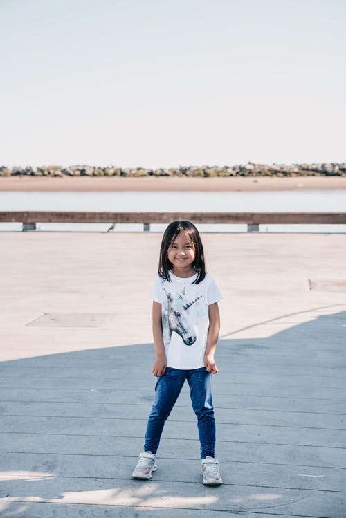 看着相机的白衬衫的可爱女孩 · 免费素材图片