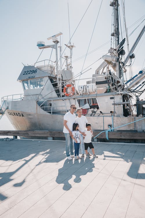 一个幸福的家庭站在船边 · 免费素材图片