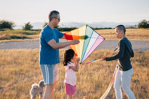 草地上放风筝的一家人 · 免费素材图片