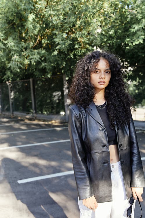 穿着黑色皮夹克的时尚女人看着相机 · 免费素材图片
