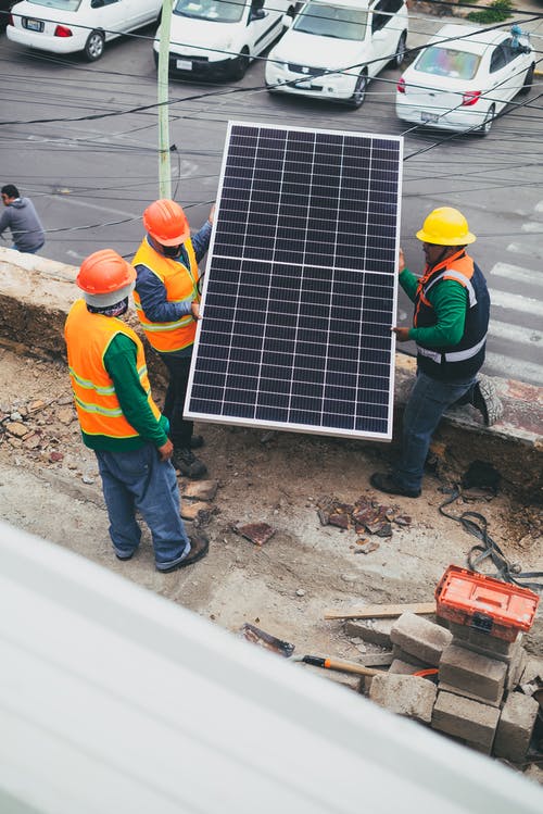 太阳能技术人员携带太阳能电池板 · 免费素材图片