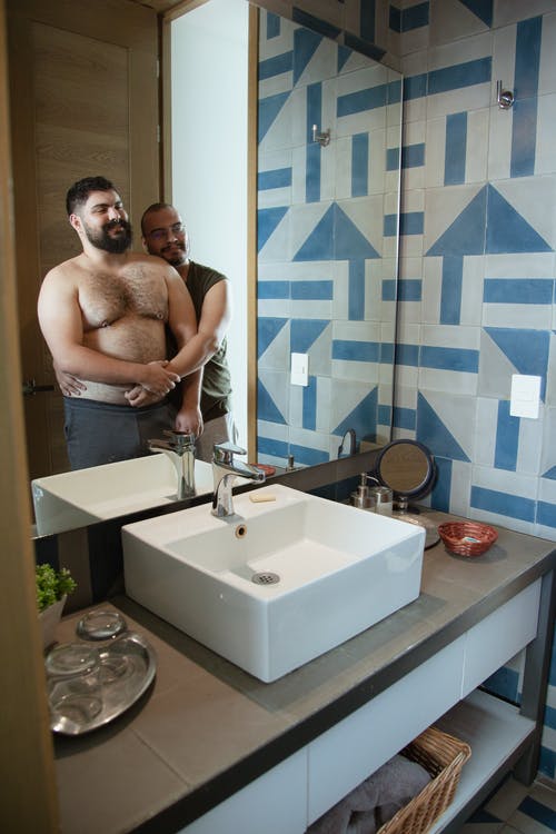 两个男人站在镜子前靠得很近 · 免费素材图片