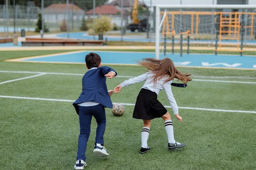 男孩和女孩踢足球 · 免费素材图片