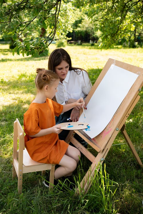 一个教女孩画画的女人 · 免费素材图片