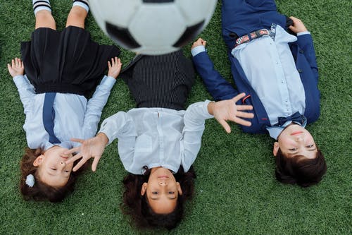 孩子们躺在草地上的高角度拍摄 · 免费素材图片