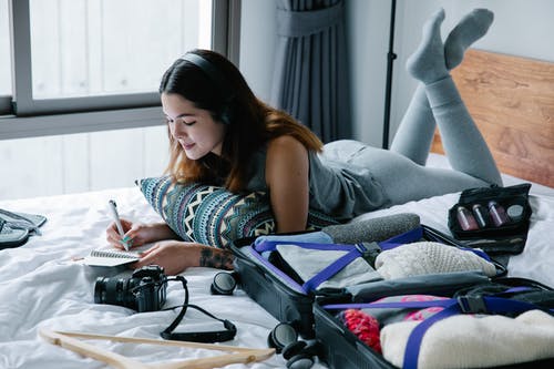 床上拿着笔的女人 · 免费素材图片