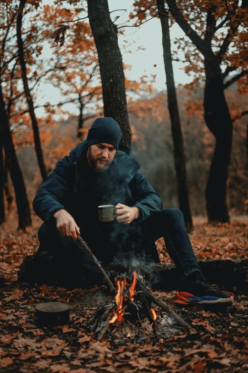 露营者在森林里生篝火 · 免费素材图片