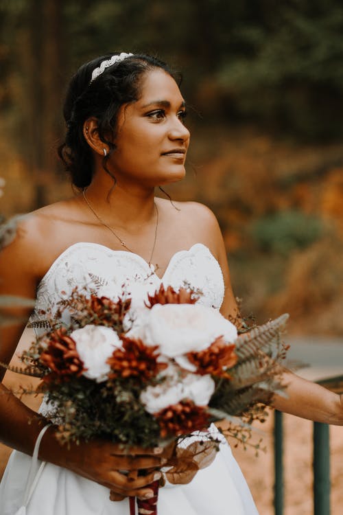 一位优雅的新娘捧着新娘花束 · 免费素材图片
