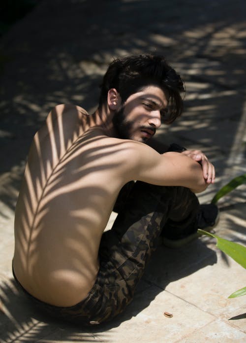 背上树叶阴影的男人 · 免费素材图片