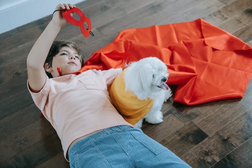 一只狗和一个披着斗篷的男孩 · 免费素材图片