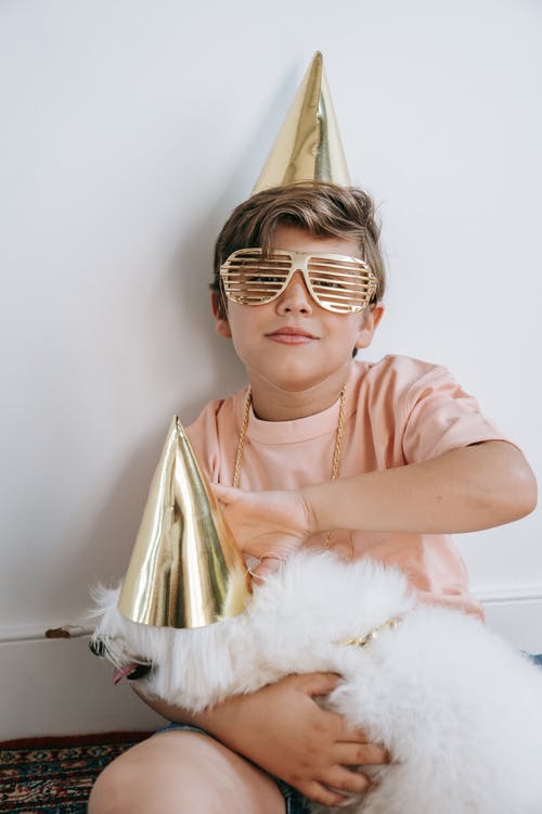 一个戴着百叶窗和派对帽的男孩 · 免费素材图片