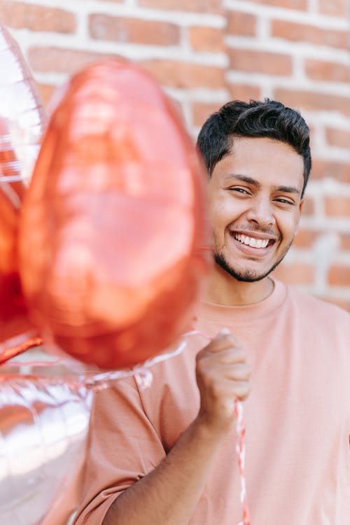 一个拿着气球的男人 · 免费素材图片