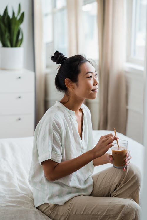 微笑的女人拿着一杯冰咖啡 · 免费素材图片