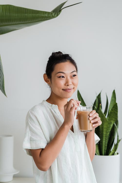 微笑的女人拿着一杯冰咖啡 · 免费素材图片