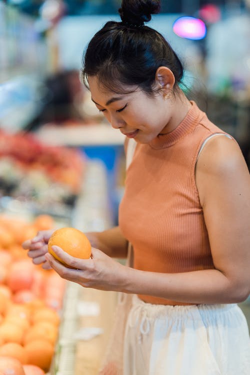 一个拿着橘子的女人 · 免费素材图片