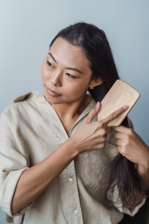 一个女人梳理她的长头发 · 免费素材图片