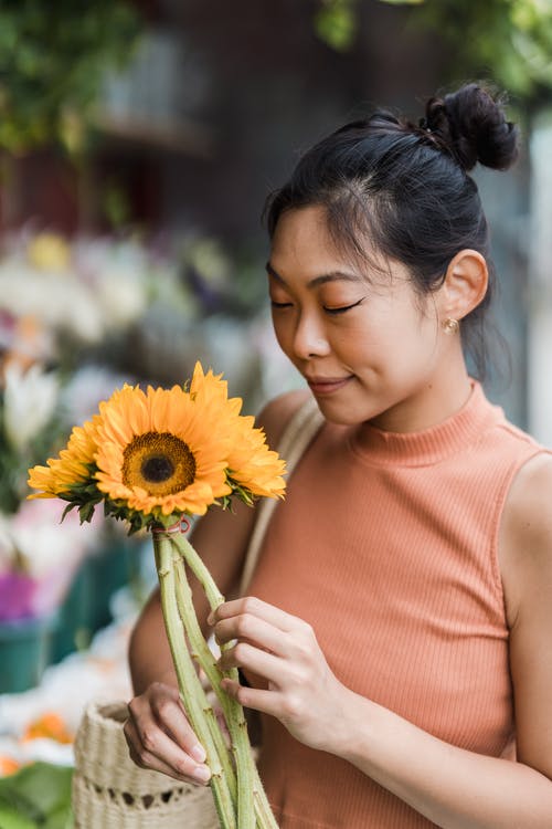 拿着向日葵的女人 · 免费素材图片