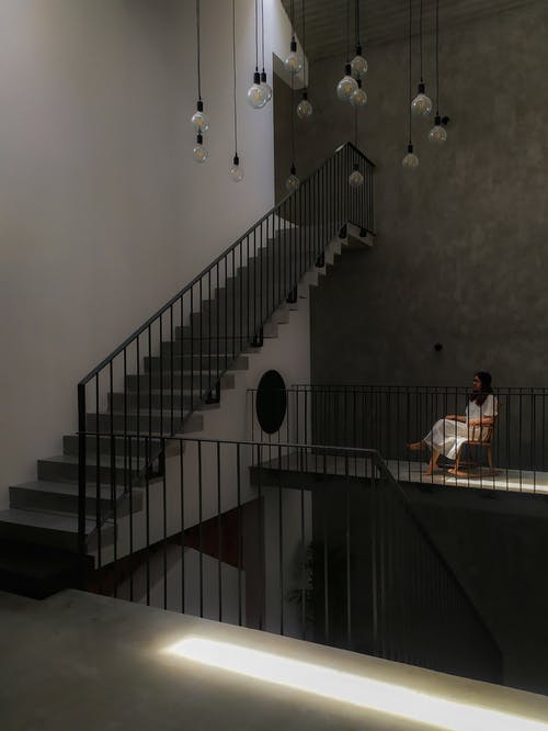 一个穿着白色连衣裙的女人坐在摇椅上 · 免费素材图片