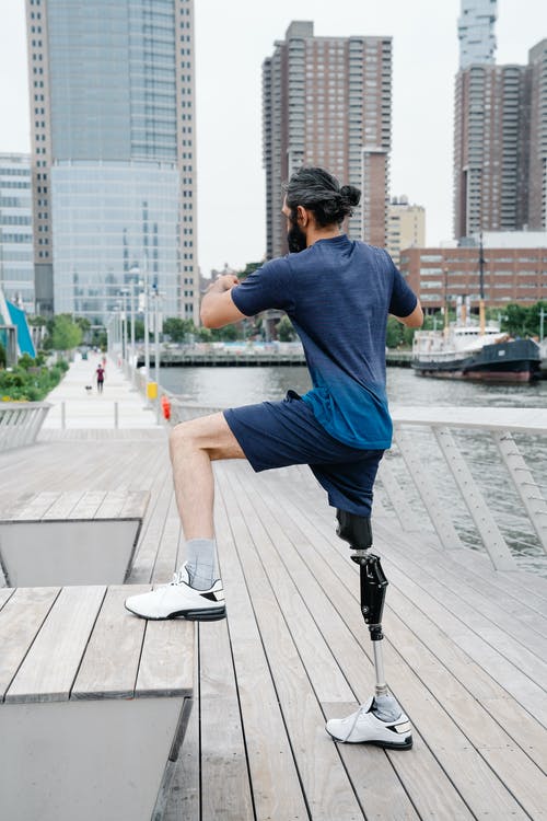在木制平台上锻炼的假腿男子 · 免费素材图片