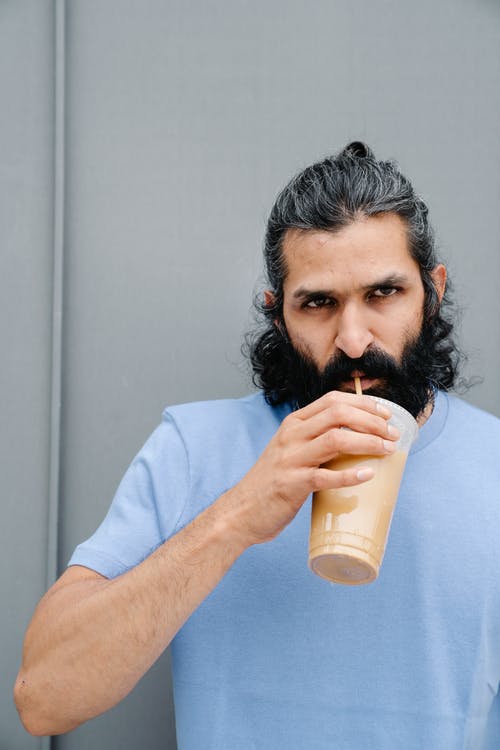 男子喝冰咖啡的特写照片 · 免费素材图片