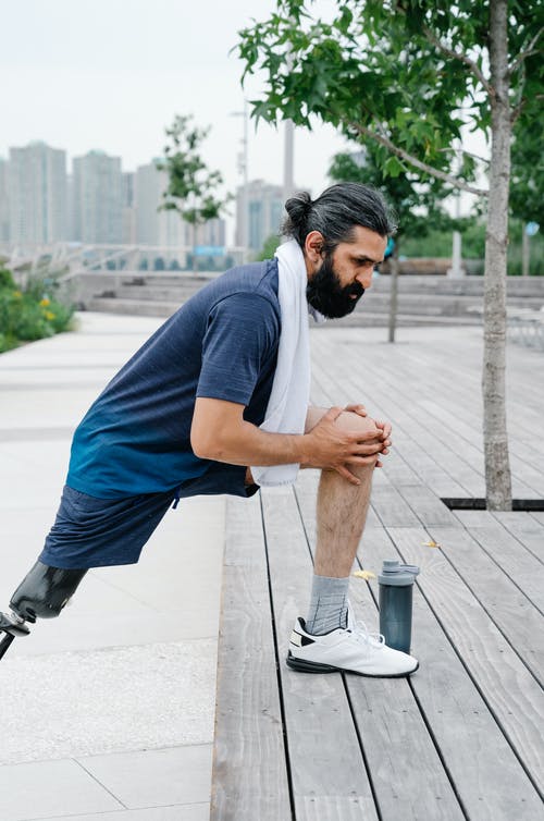 在木制平台上做伸展运动的人 · 免费素材图片