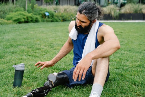 假肢躺在草地上的男人 · 免费素材图片